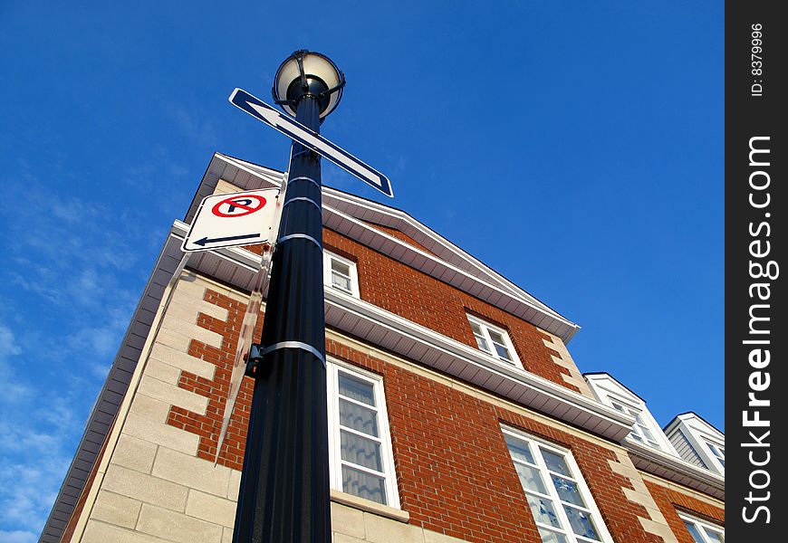 A town home with a light post and a blue sky