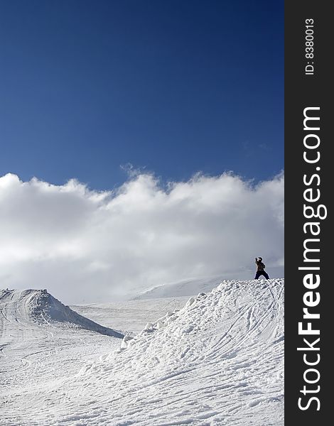 Snowboarder poses a ninja in mountains. Snowboarder poses a ninja in mountains