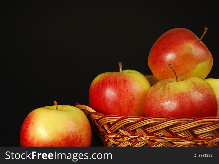 Apples in a basket on a black background