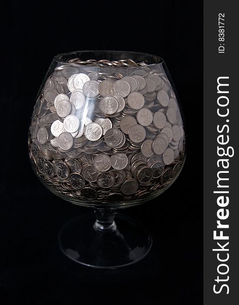 Wide glass with money isolated on black