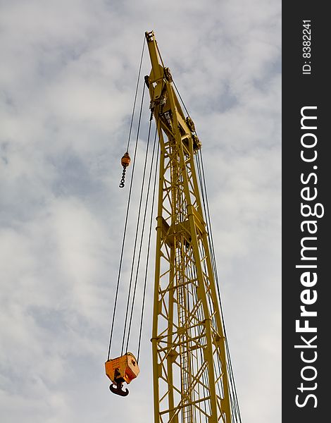 Industrial crane with blue cloudy sky background. Industrial crane with blue cloudy sky background