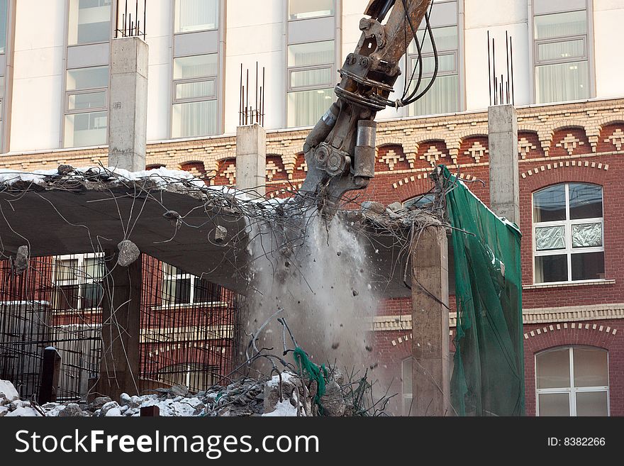 Heavy dredger is demolishing a house. Heavy dredger is demolishing a house