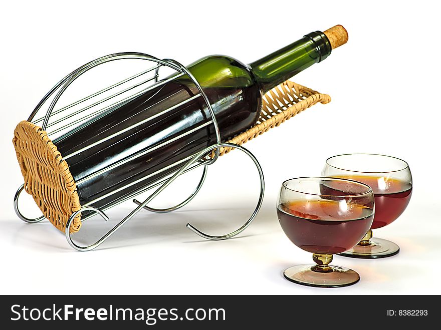 Wine bottle in basket and two glasses