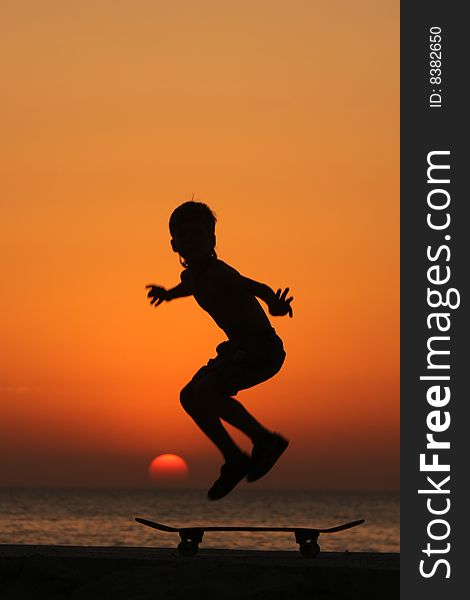 Young skater in a jump at the sunset
