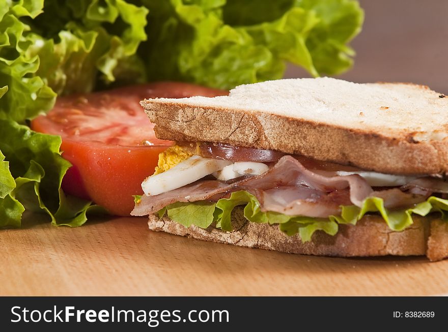 Bacon and egg sandwich on wooden board