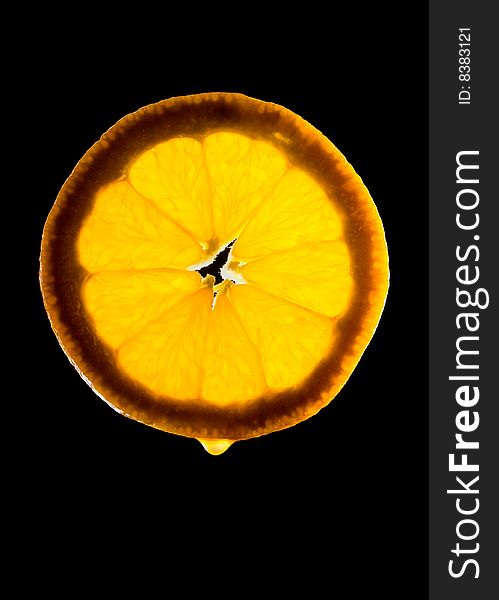 Semi-transparent orange slice with juice drop on black. Semi-transparent orange slice with juice drop on black