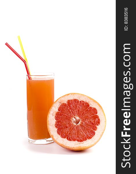 Half of grapefruit and juice in glass on white