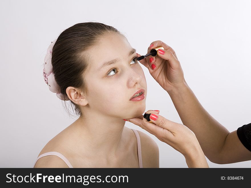 Teen girl putting on make up by makeup artist. Teen girl putting on make up by makeup artist