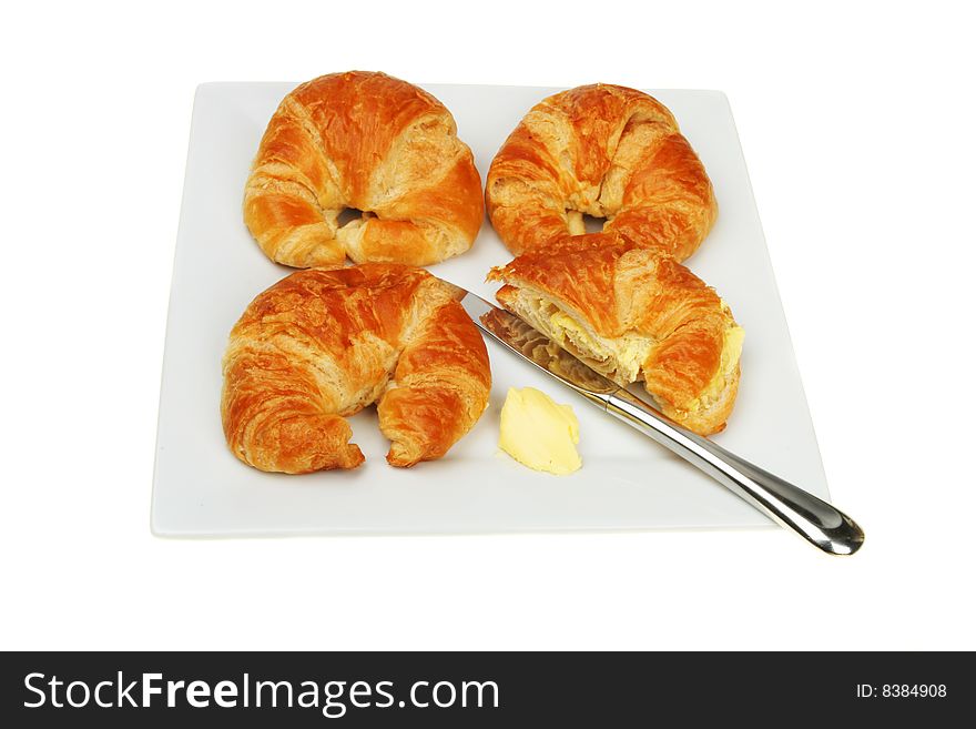 Croissants on a plate with knife and butter. Croissants on a plate with knife and butter