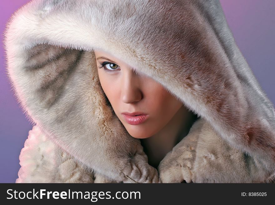 Attractive angry woman wearing fur isolated on blue background. Attractive angry woman wearing fur isolated on blue background