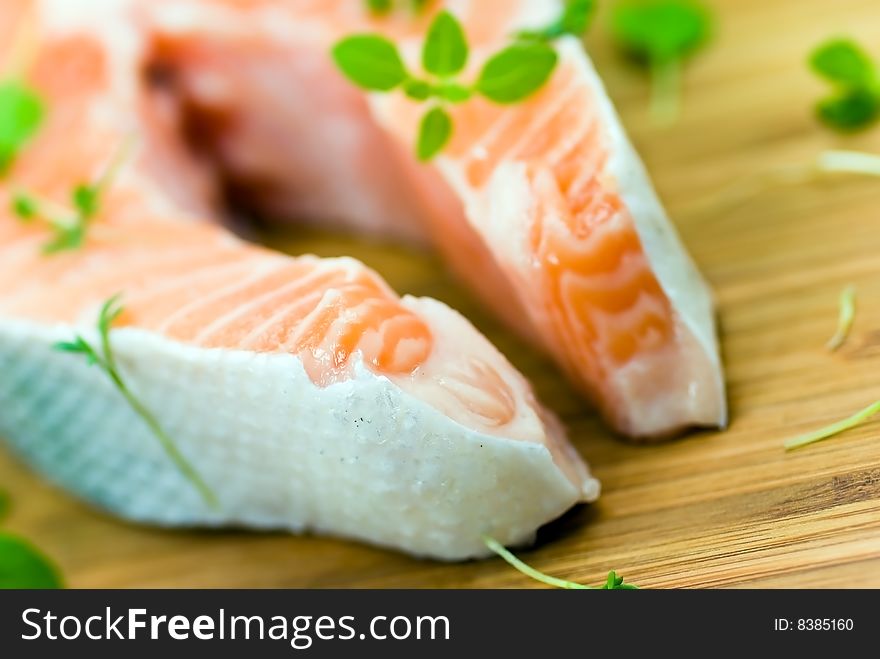 Salmon raw on the wooden background with thyme and lemon.