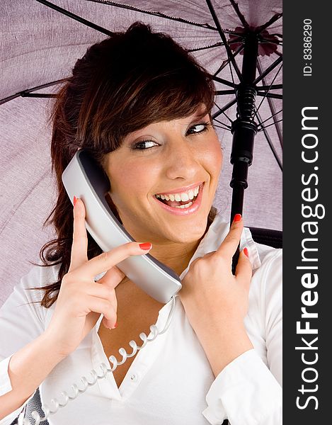 Front view of smiling woman talking on phone and holding an umbrella