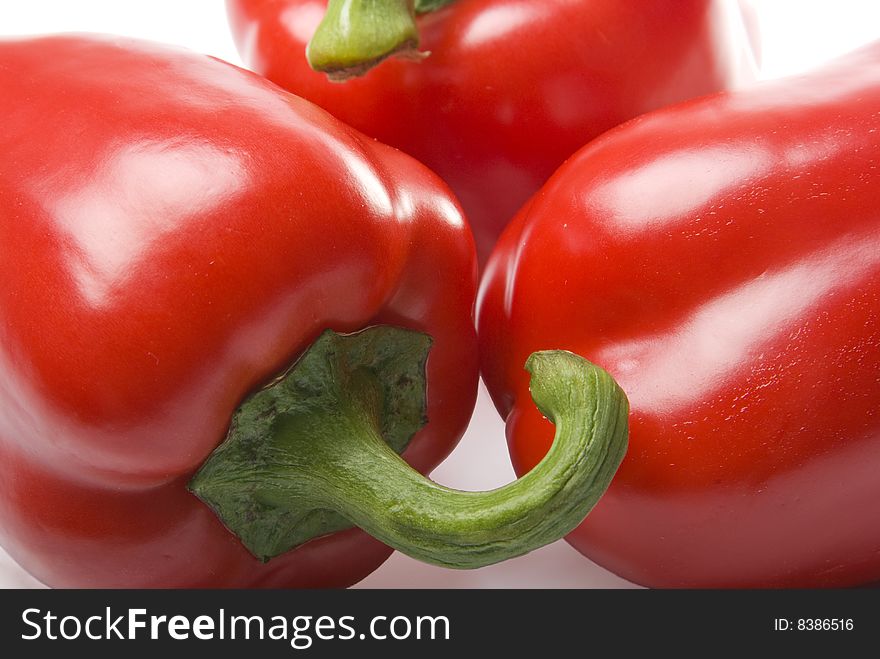 There are a three red sweet peppers on the white background. There are a three red sweet peppers on the white background