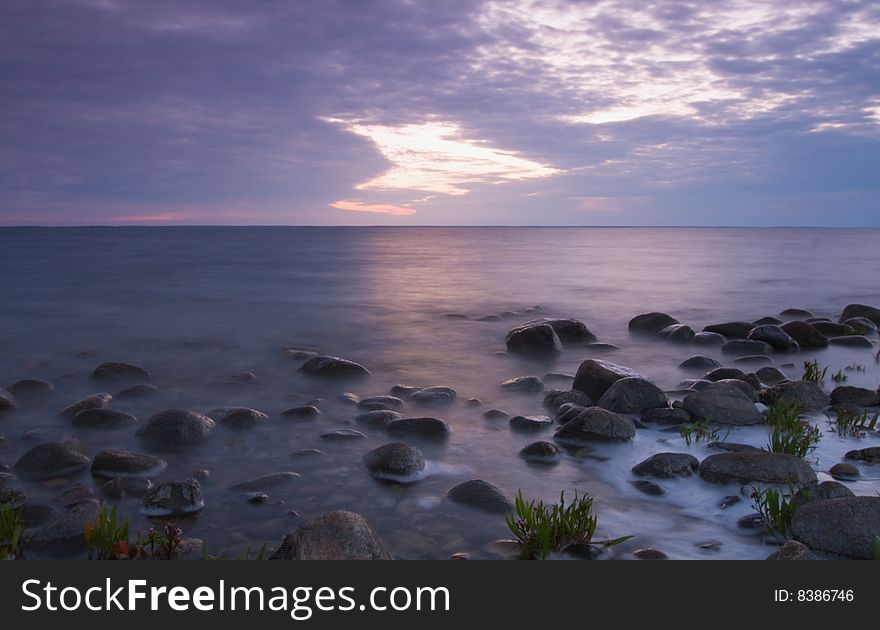 Wide angle photograph of shoreline. Opening in the clouds.