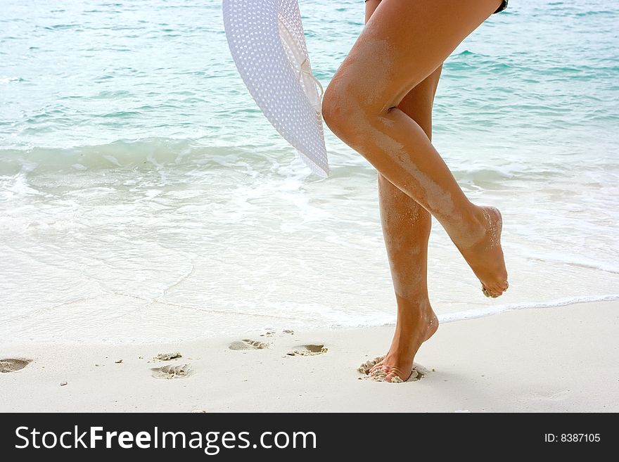 White hat in hands of a young lady on the beach. White hat in hands of a young lady on the beach