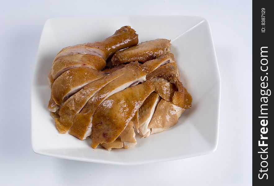 Sliced fried chicken leg on a white plate