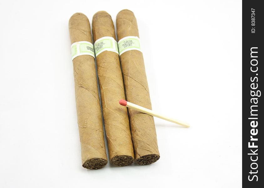 Three cigars and match isolated on a white background.