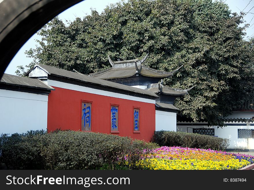Beautiful flowers and trees in front of the enclosure wall with its distinct flying-eaved roofs on the entrance gate at Wang Cong Ci Park in Pixian, China - Lee Snider Photo. Beautiful flowers and trees in front of the enclosure wall with its distinct flying-eaved roofs on the entrance gate at Wang Cong Ci Park in Pixian, China - Lee Snider Photo.