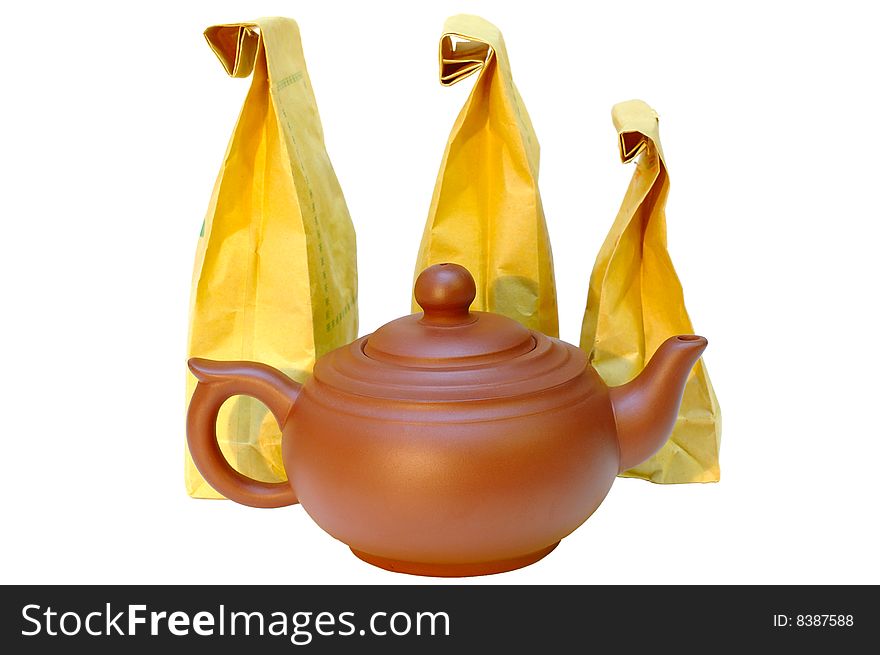 Chinese pottery (clay) teapot and tea in paper bags on isolated background. Chinese pottery (clay) teapot and tea in paper bags on isolated background.