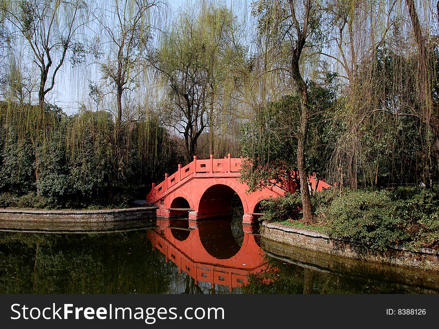 A graceful three arched orange bridge spans the lagoon at Wang Cong Ci Park in Pixian, Sichuan province, China - Lee Snider Photo. A graceful three arched orange bridge spans the lagoon at Wang Cong Ci Park in Pixian, Sichuan province, China - Lee Snider Photo.