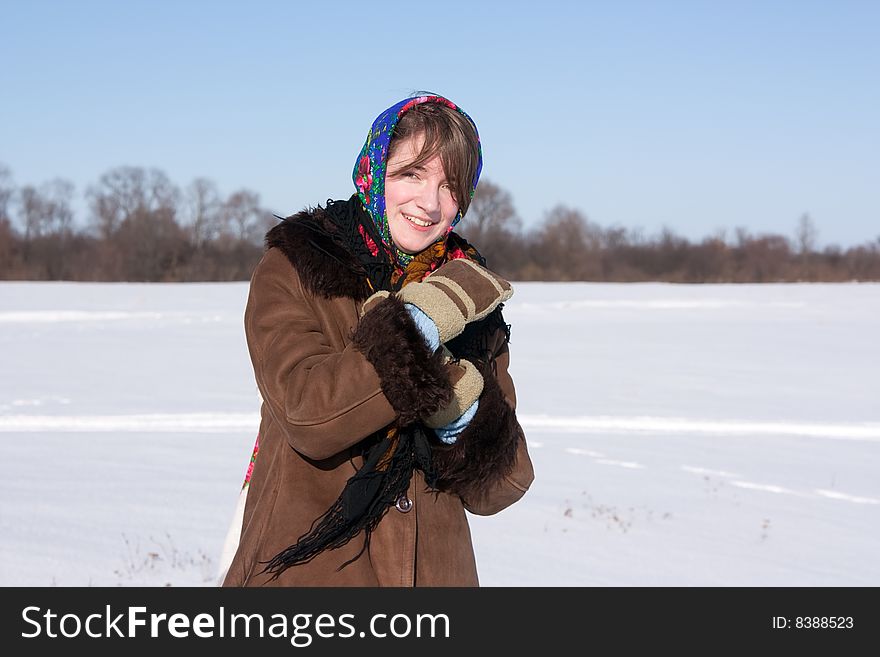 Girl in russian traditional clothes against  winter landscape
