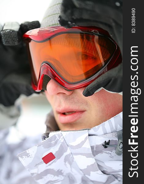 Snowboarder looking at camera through eyeglasses. Snowboarder looking at camera through eyeglasses