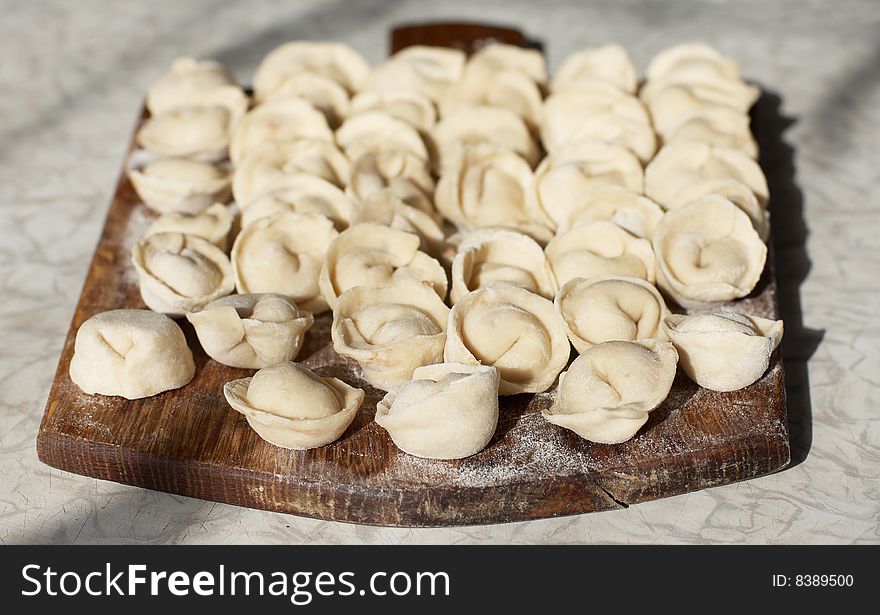 Uncooked meat dumplings on kitchen preparation table