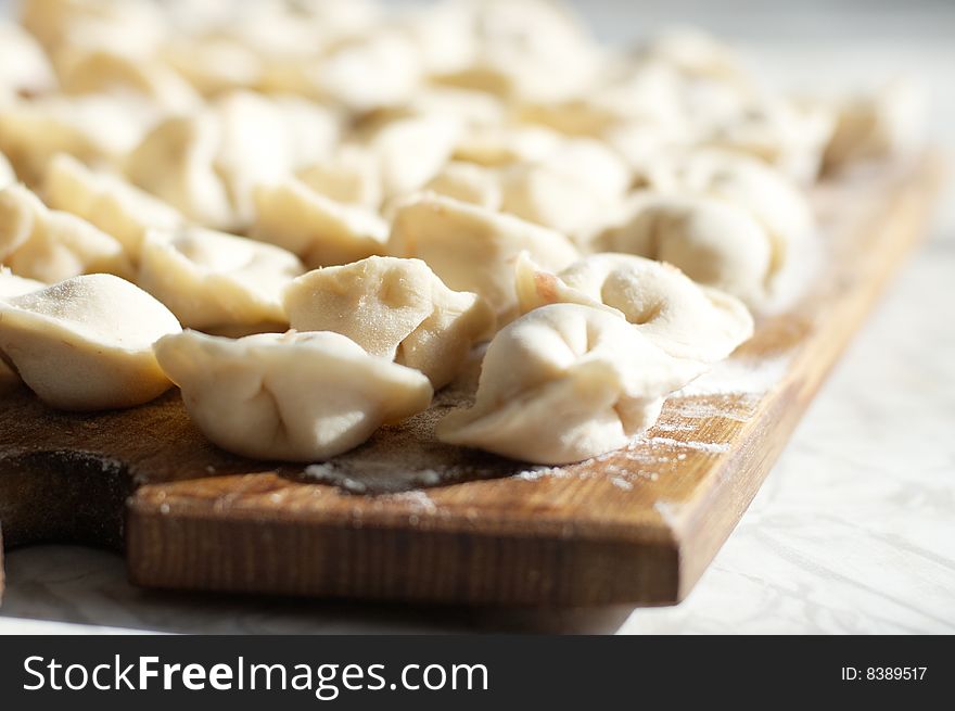 Uncooked meat dumplings on kitchen preparation table