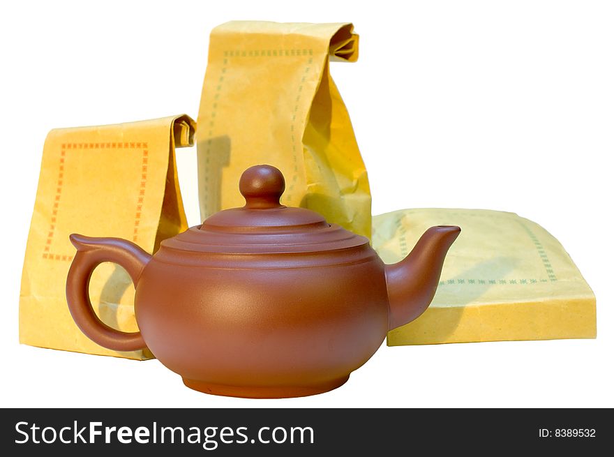 Chinese pottery (clay) teapot and tea in paper bags on isolated background. Chinese pottery (clay) teapot and tea in paper bags on isolated background.