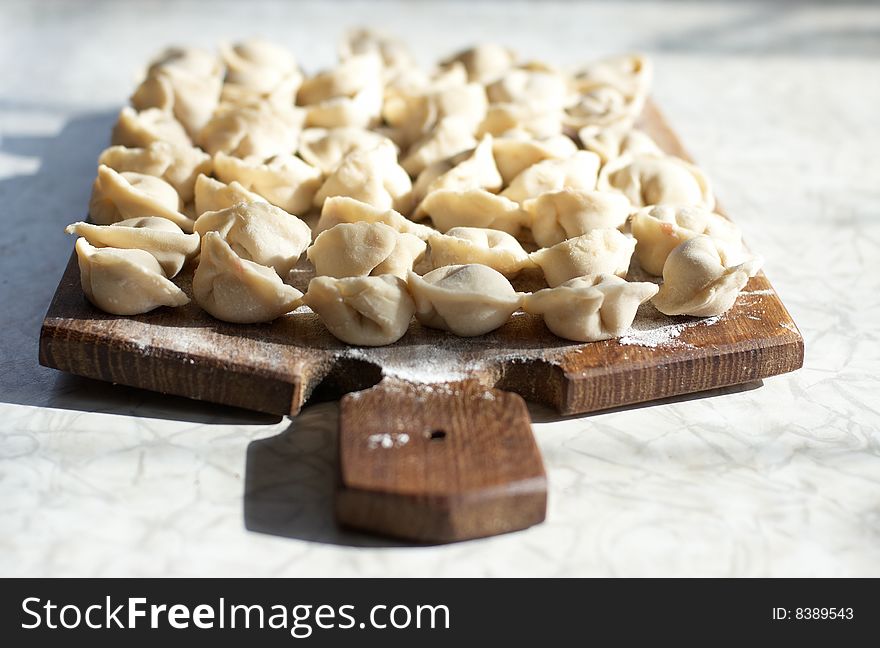 Uncooked meat dumplings on kitchen preparation table