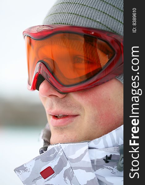 Snowboarder looking at camera through eyeglasses. Snowboarder looking at camera through eyeglasses