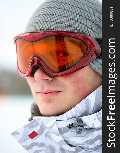 Snowboarder looking at camera through eyeglasses. Snowboarder looking at camera through eyeglasses