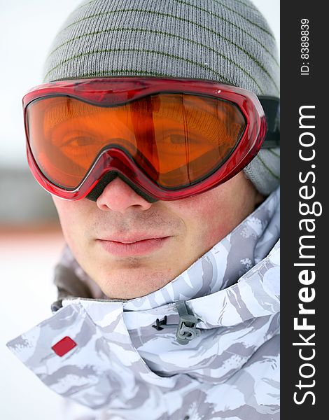 Snowboarder looking at camera through eyeglasses. Snowboarder looking at camera through eyeglasses