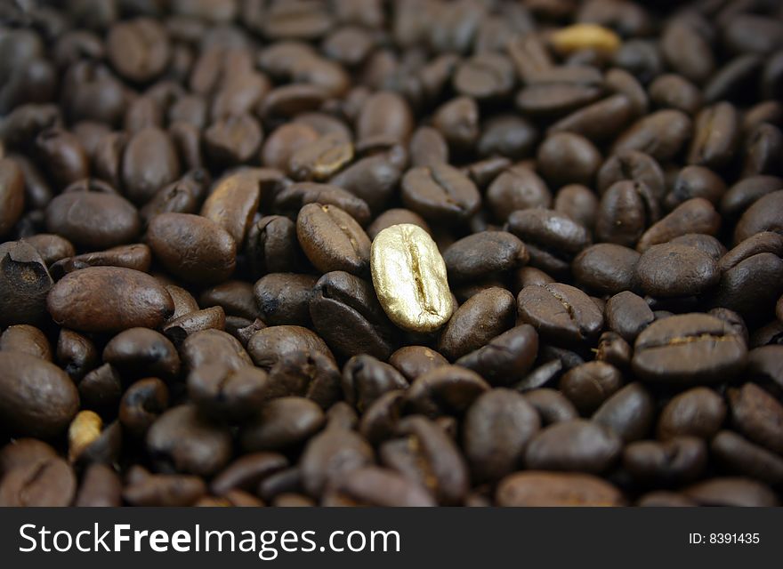 Golden Coffee Bean on a bed of normal coffee beans