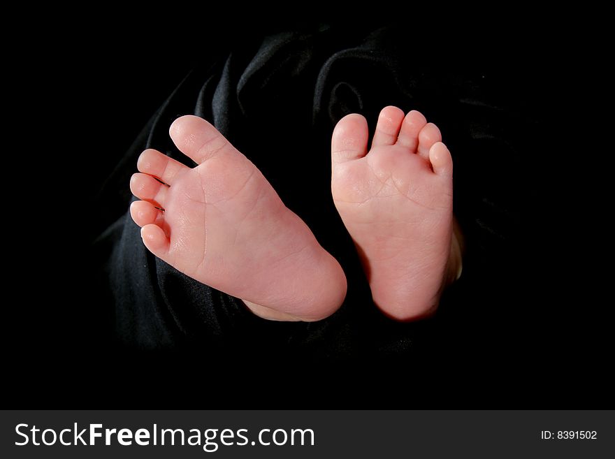 Baby feet in a black  towel