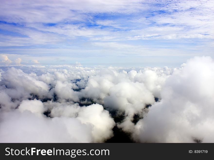 Aerial view of cloudy blue sky from aircraft window. Aerial view of cloudy blue sky from aircraft window.