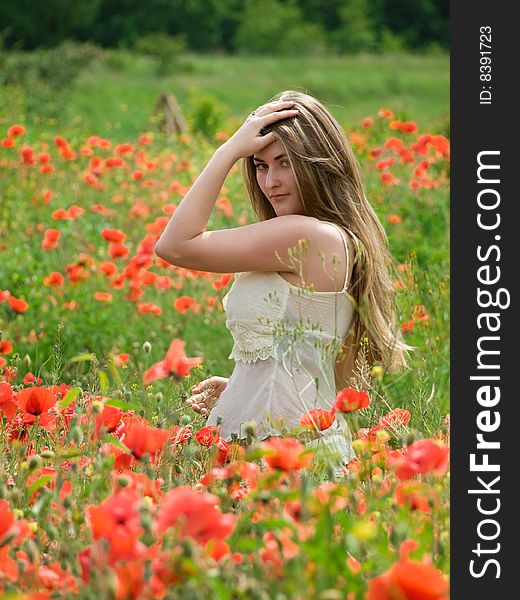 Young girl with long hair in poppies field