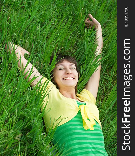 Smiling girl lying on green grass and looking up. Smiling girl lying on green grass and looking up