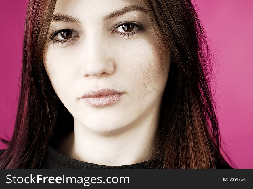 Portrait of a young woman on the pink background with freckles and dry lips. Portrait of a young woman on the pink background with freckles and dry lips