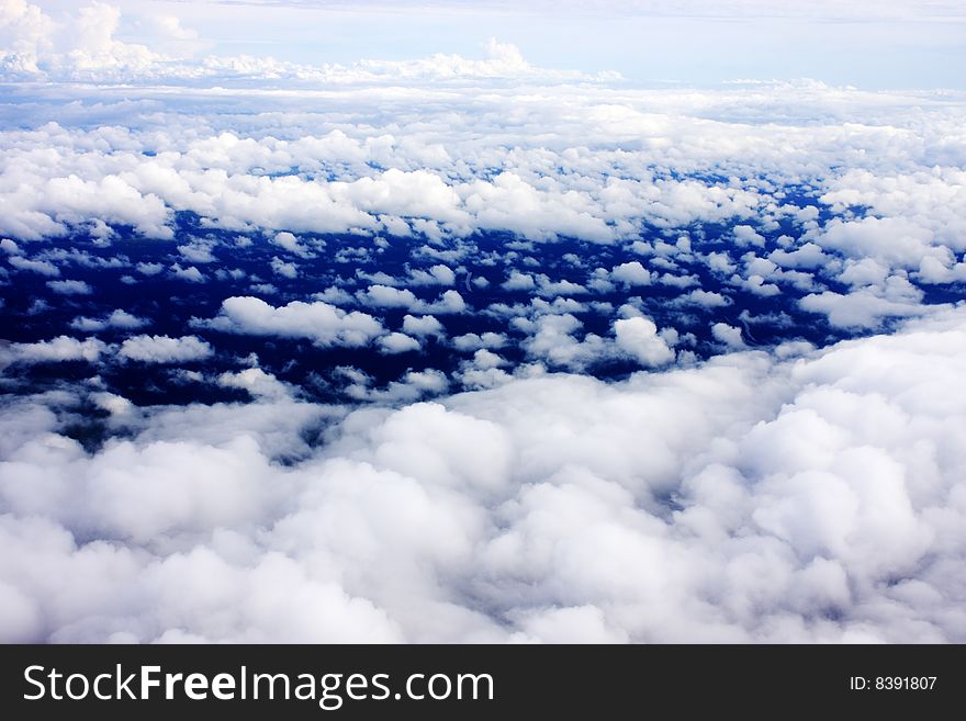 Aerial view of cloudy blue sky from aircraft window. Aerial view of cloudy blue sky from aircraft window.