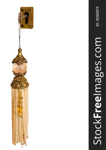 Key in a lock with a fancy and elaborate tassel key ring. Key in a lock with a fancy and elaborate tassel key ring