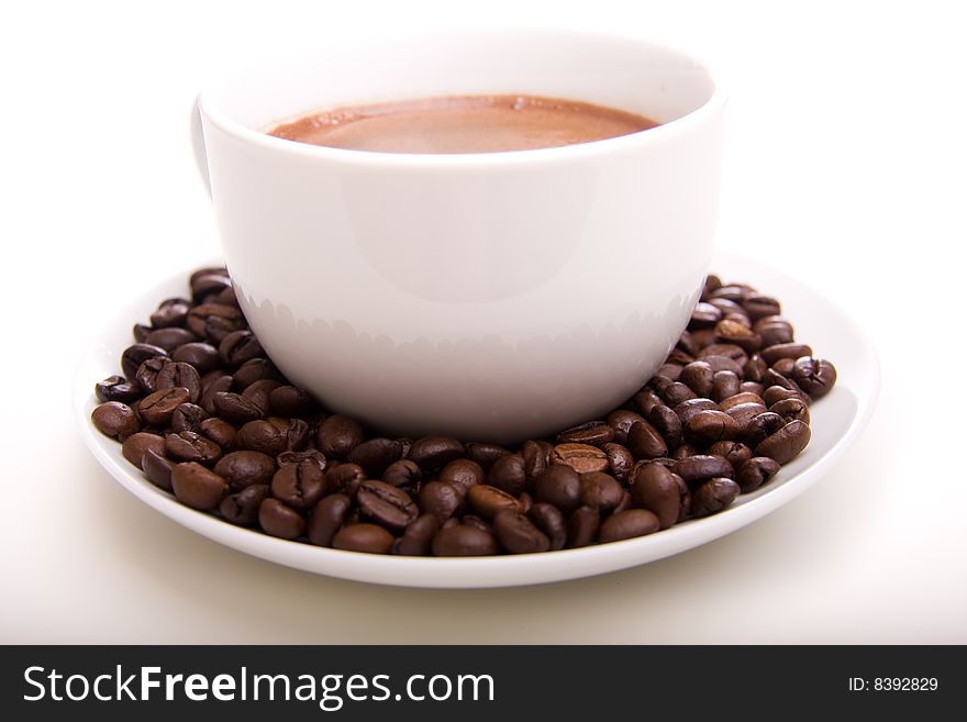 Close-up of a cup of hot coffee and beans