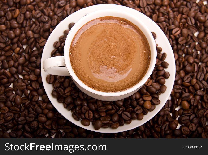 Close-up of a cup of hot coffee and beans