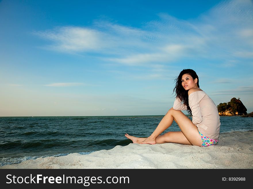 Young woman relaxing by the summer beach. Young woman relaxing by the summer beach