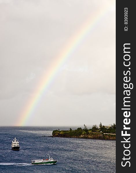 Two ferries cruising between islands under an early morning rainbow. Two ferries cruising between islands under an early morning rainbow