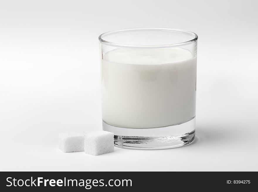 Front view of glass of milk with sugar on white background