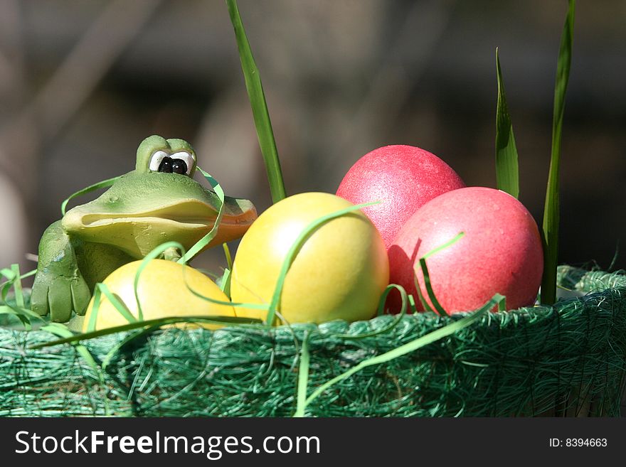 There is a green basket with easter bright yellow and pink eggs. There is a green basket with easter bright yellow and pink eggs.