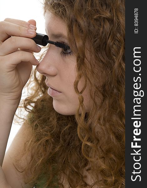 Red haired female teenager with mascara, when making the eyes up