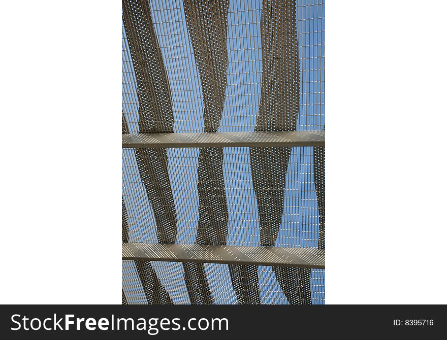 Abstract Twisted and Perforated Metal Against Serene Blue Sky. Abstract Twisted and Perforated Metal Against Serene Blue Sky