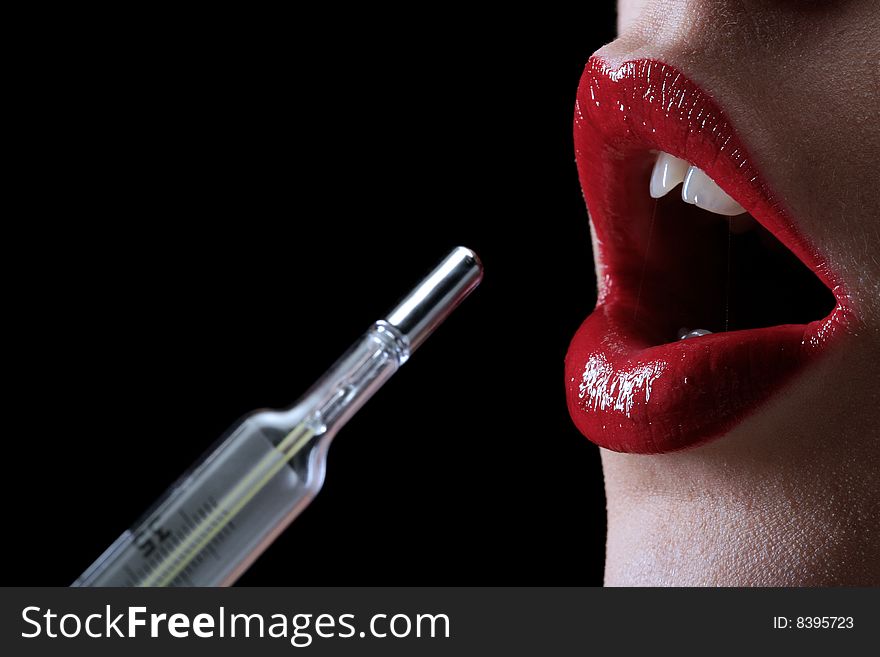 A red woman lips with thermometer on the black background. A red woman lips with thermometer on the black background